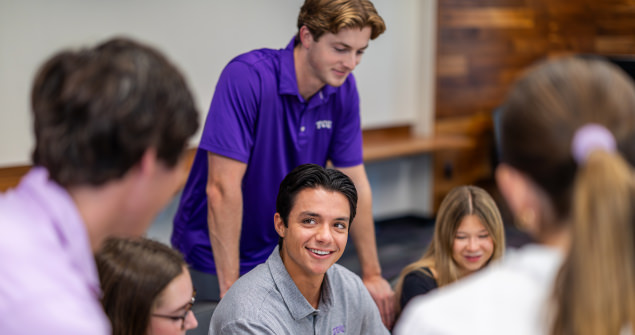 Students gathered around talking and smiling