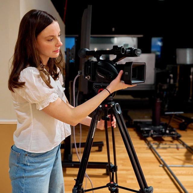 Student adjusts filming camera