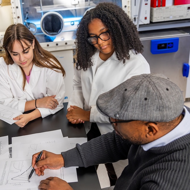 Geology students look at graphs with professor