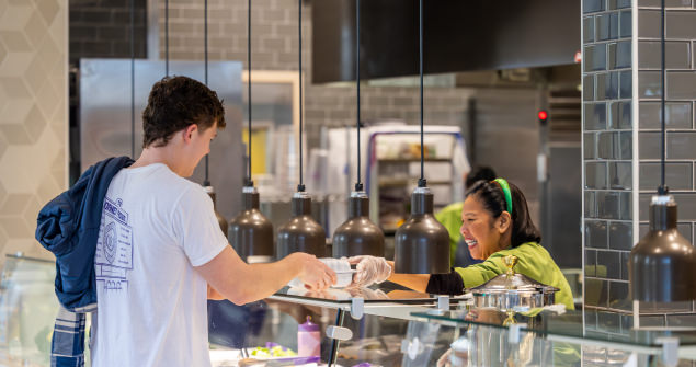 Two male TCU students share a laugh over lunch at the campus main dining hall