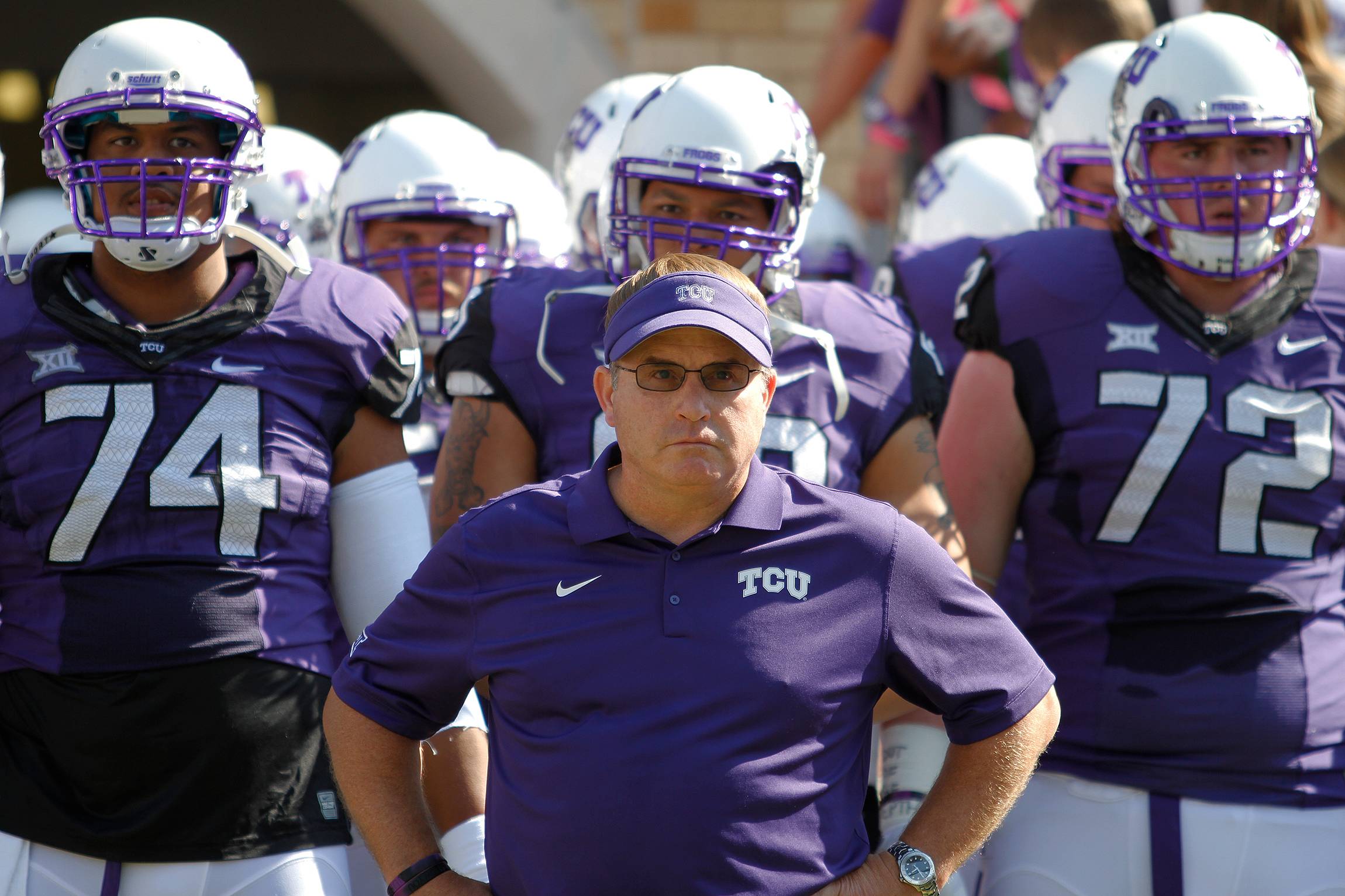 Gary Patterson standing infront of TCU football players