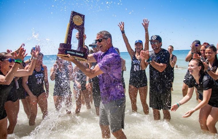 Mike Buddie director of intercollegiate athletics celebrates with the women’s beach volleyball team.